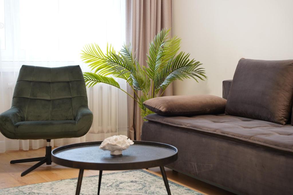 a living room with a couch and a chair and a table at Sonata apartment in Panevėžys