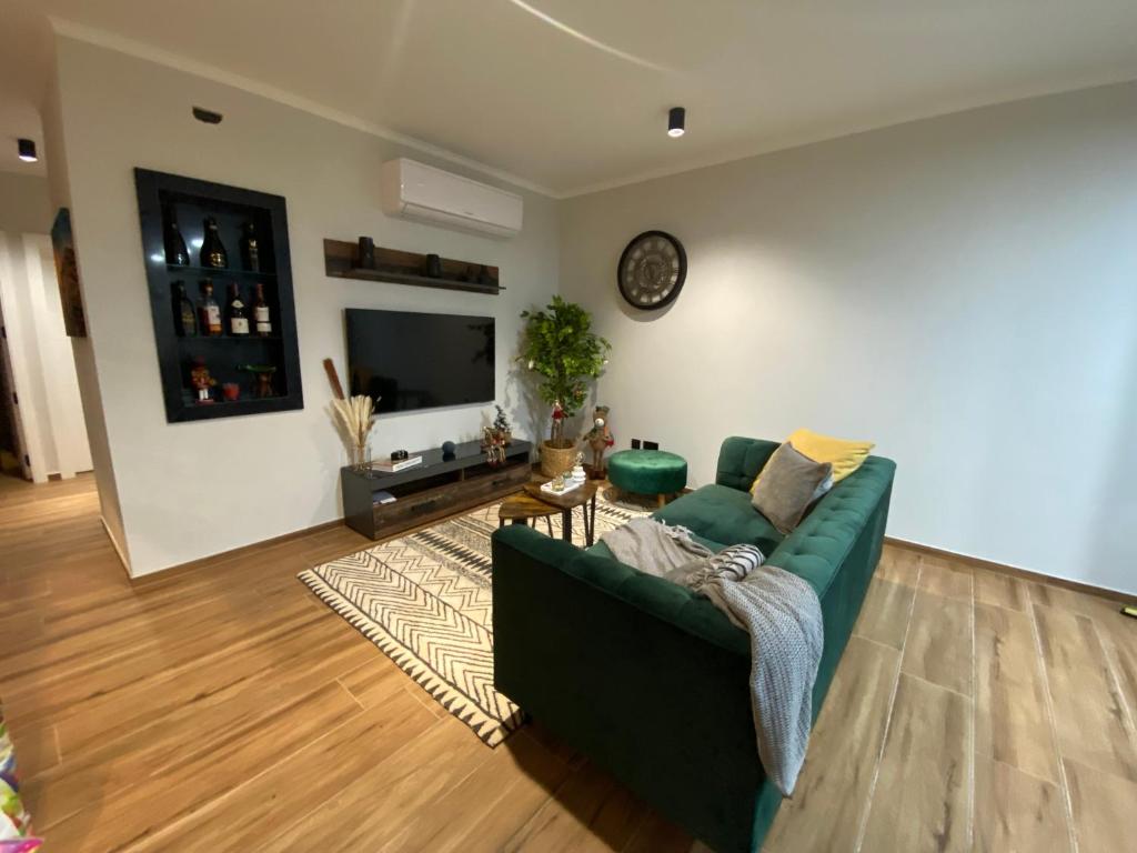 a living room with a green couch and a television at Marsalforn luxurious Apartment in Marsalforn