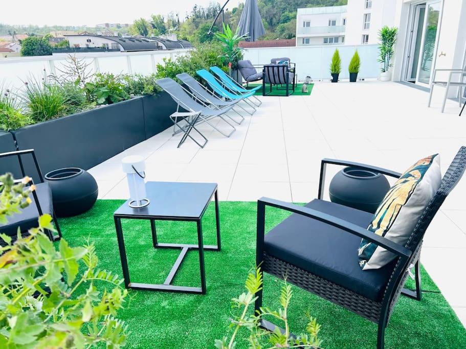 een patio met stoelen, een tafel en gras bij Bel Appartement avec Terrasse privée 86m2 in Noisy-le-Sec