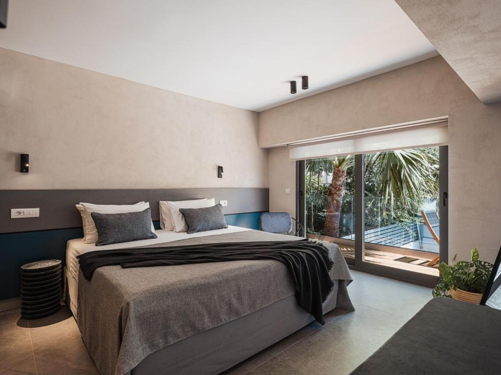 een slaapkamer met een groot bed en een groot raam bij Grand Residences in Chania
