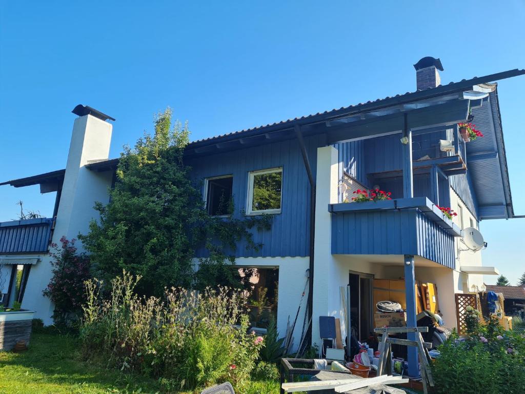 ein blau-weißes Haus mit einem Balkon in der Unterkunft Alpenblick Pang in Rosenheim
