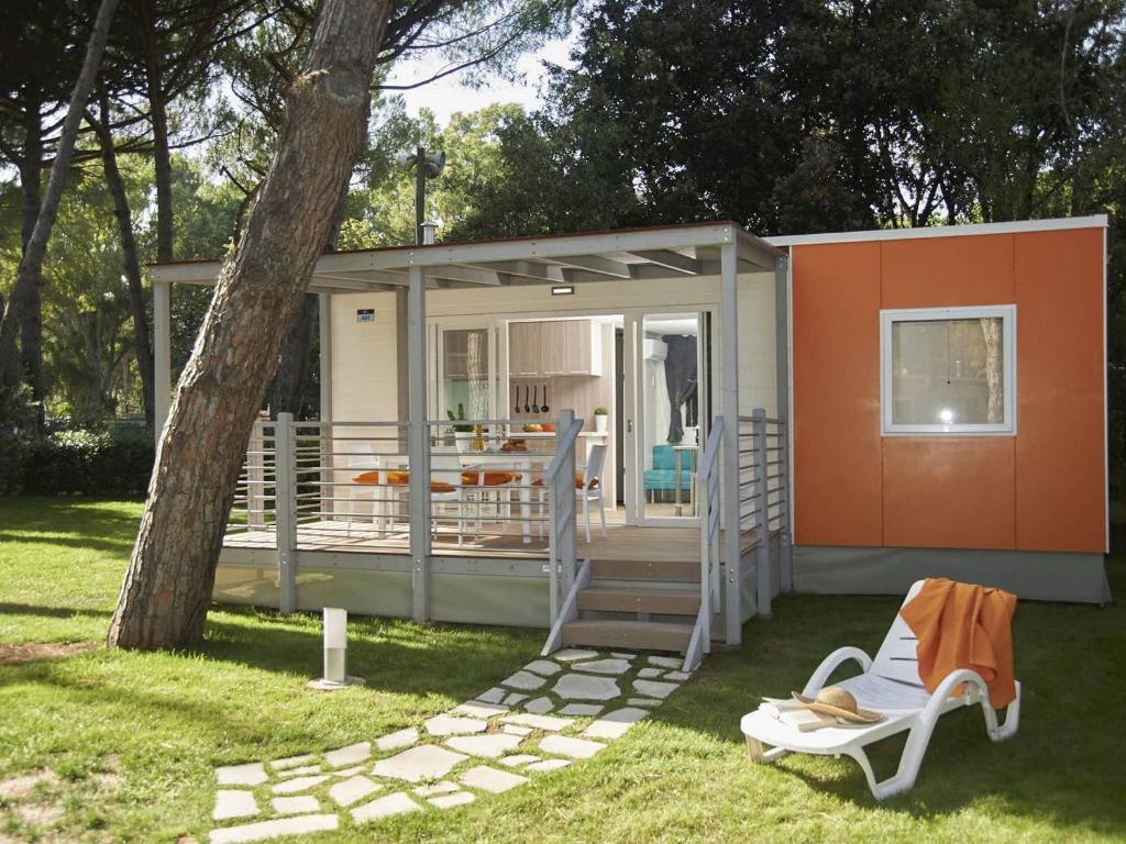 a tiny house with a porch and a deck at Detached chalet with AC, in a natural park on the coast in Baia Domizia