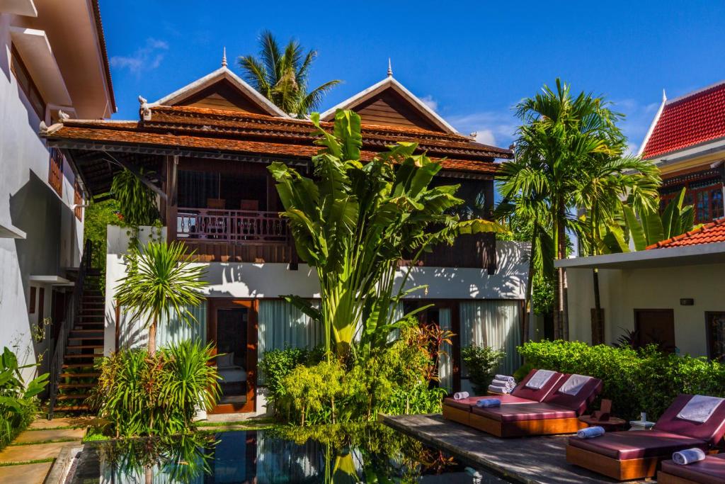 a villa with a swimming pool in front of a house at Sokkhak Boutique Resort & Spa in Siem Reap