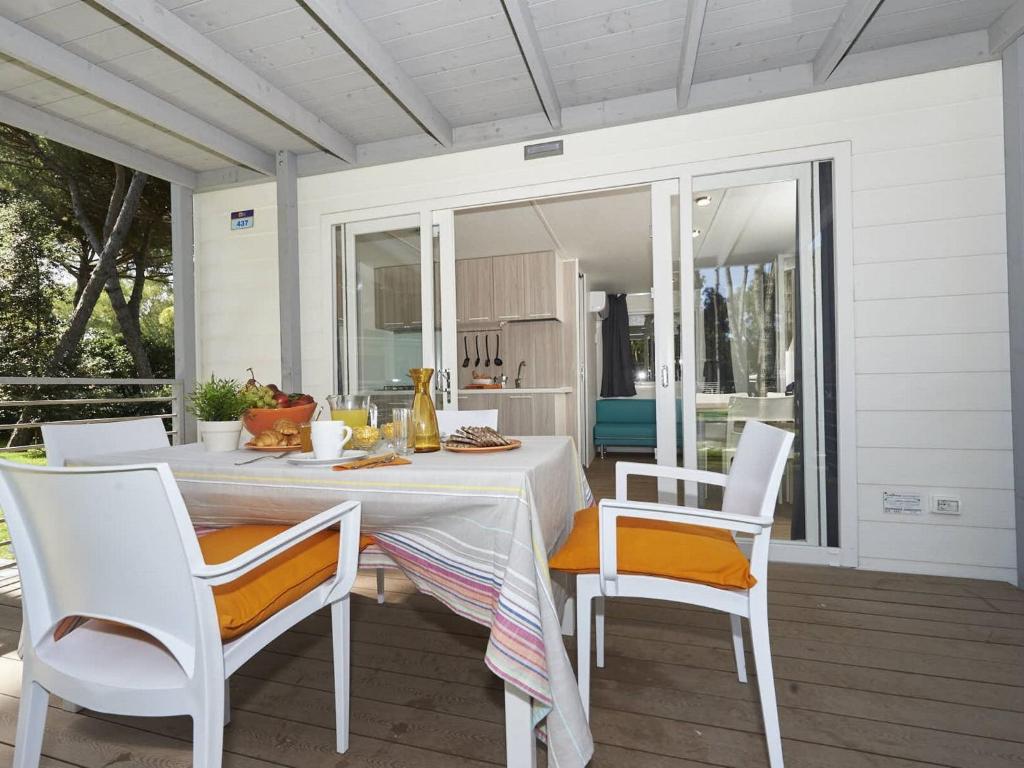 a white dining table and chairs on a porch at Detached chalet with AC, in a natural park on the coast in Baia Domizia