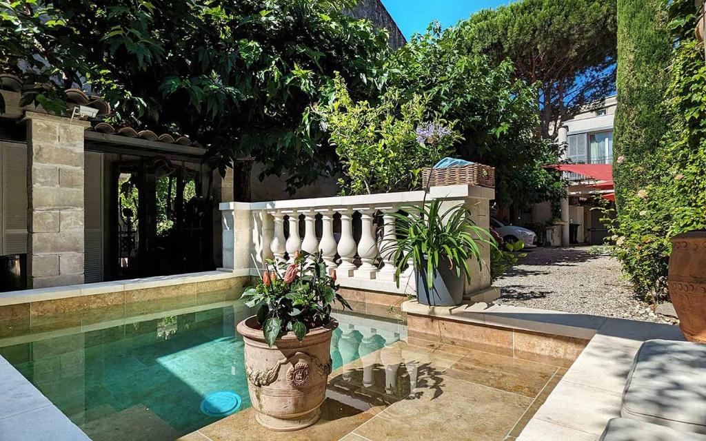 a house with a swimming pool with a fence and plants at Les Studios de la Madeleine in Avignon