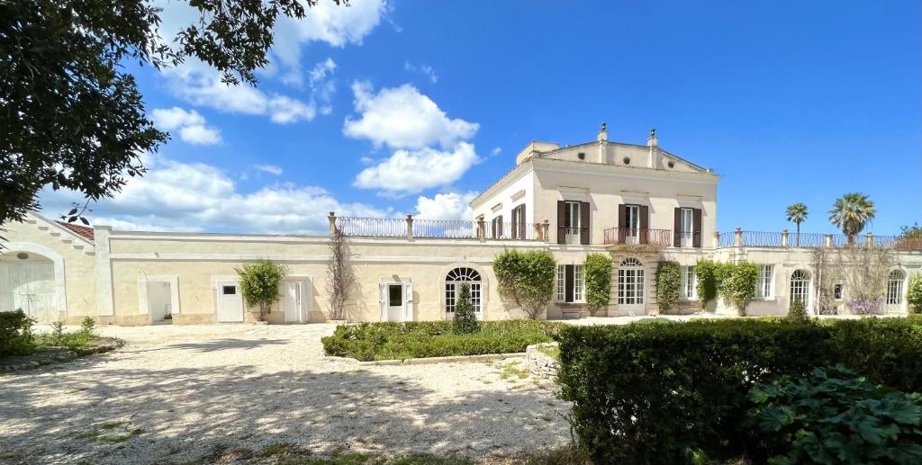 una grande casa bianca con una palma di Masseria Villa Gioia a Corato