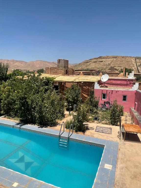 une maison avec une piscine en face d'une maison dans l'établissement Riad Bouchra, à Tamtetoucht