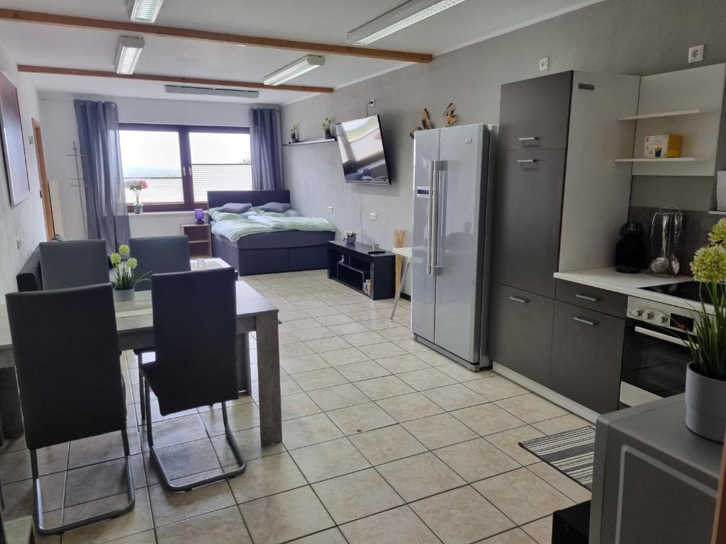 cocina y sala de estar con mesa y nevera en Ferienwohnung beim Nationalpark Eifel, en Nideggen