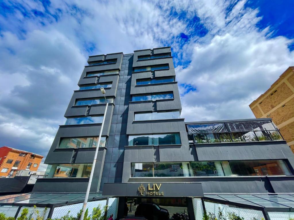 a tall gray building with a sky in the background at Liv Hotels in Bogotá