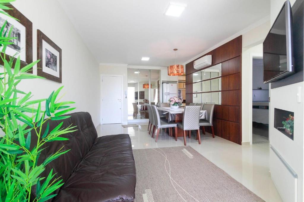 sala de estar con sofá y comedor en Aluguel Apartamento 2 quartos c/ 1 suíte | Bombas/SC, en Bombinhas