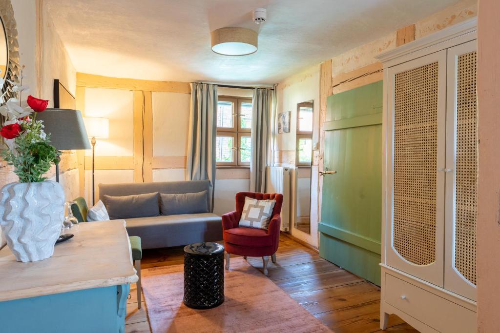 ein Wohnzimmer mit einem Sofa und einem Stuhl in der Unterkunft Up Hus Hotel Neuruppin in Neuruppin