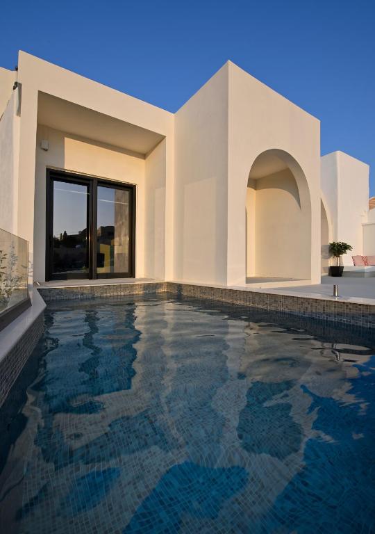 a swimming pool in front of a house at Artium Villa with Outdoor Pool hosted by K&K in Foinikiá