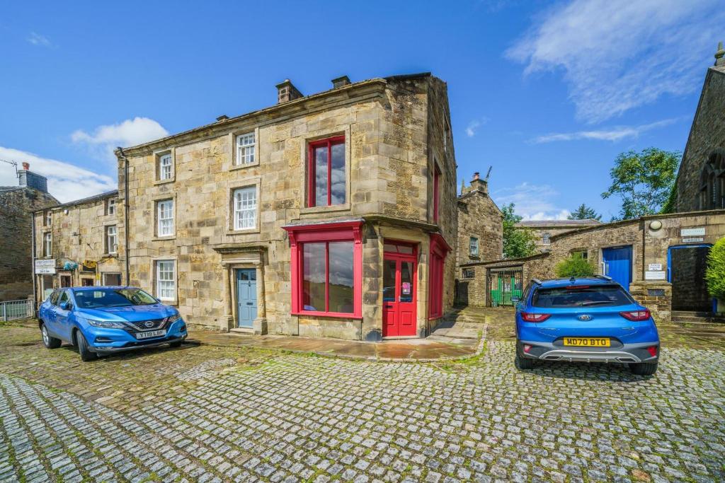 two cars parked in front of a stone building at Bank House | Peak District in Longnor