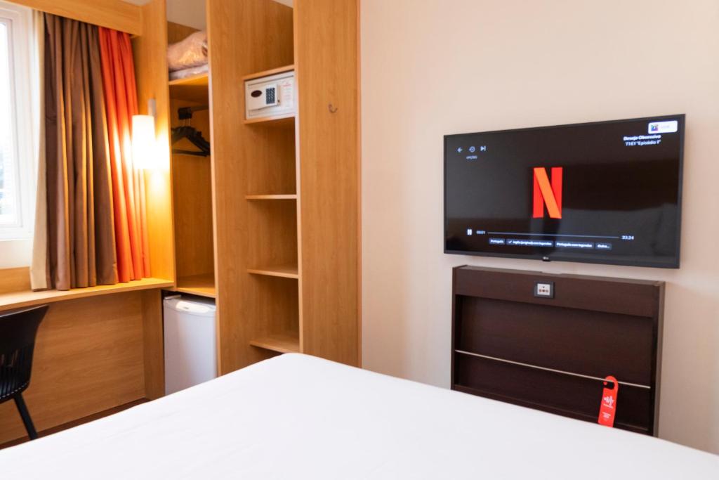 阿雷格里港的住宿－宜必思博爾特阿爾格雷溫托酒店，一间带电视和一张床的卧室