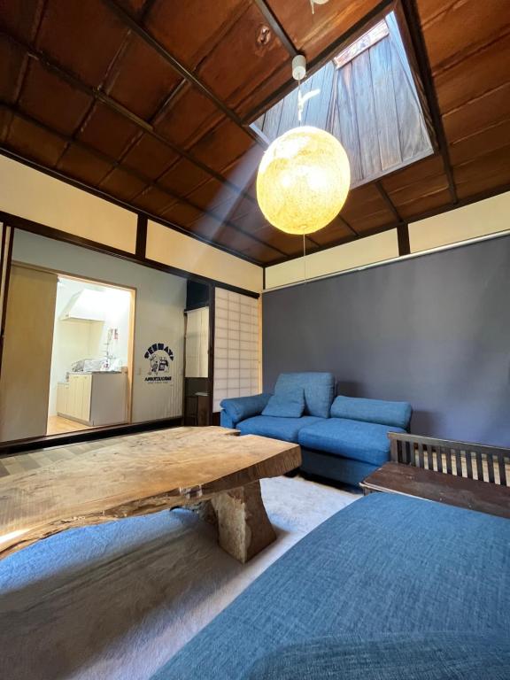 a living room with a table and a blue couch at Only one group stays per day -Tenmaya-家族や仲間と貸し切りゲストハウス 天満屋 in Nakatsugawa