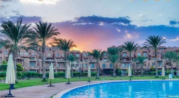 a resort with a large swimming pool and palm trees at Royal Chalet Sea View - Stella Di Mare - Families in Az Zafarani