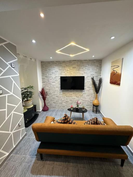 een woonkamer met een bank en een tv bij Mira loft in Bejaïa