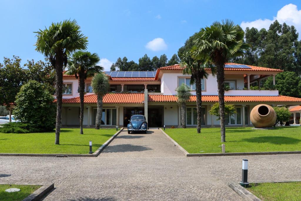Vilela的住宿－Casa de Lamaçais，棕榈树屋前的停车场