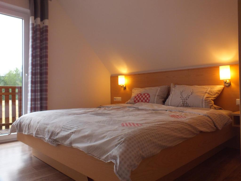 ein Schlafzimmer mit einem großen Bett mit zwei Lampen in der Unterkunft Ferienhaus Moni mit 2 separaten Wohnungen am Silbersee in Frielendorf