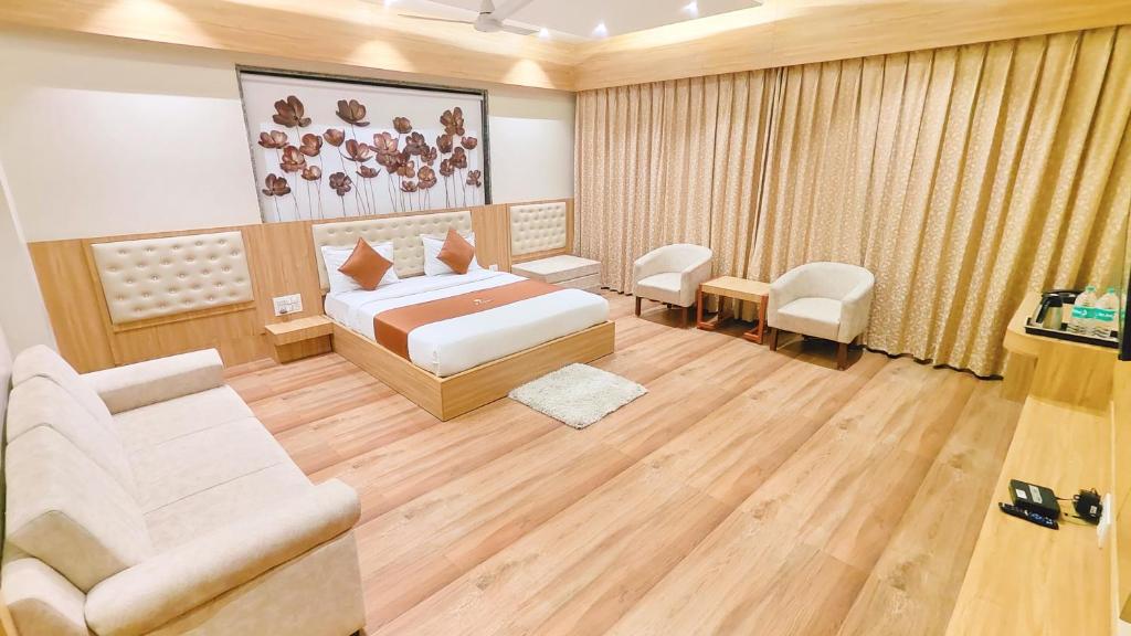 a bedroom with a bed and a couch and a chair at Hotel 9 Coin in Shirdi