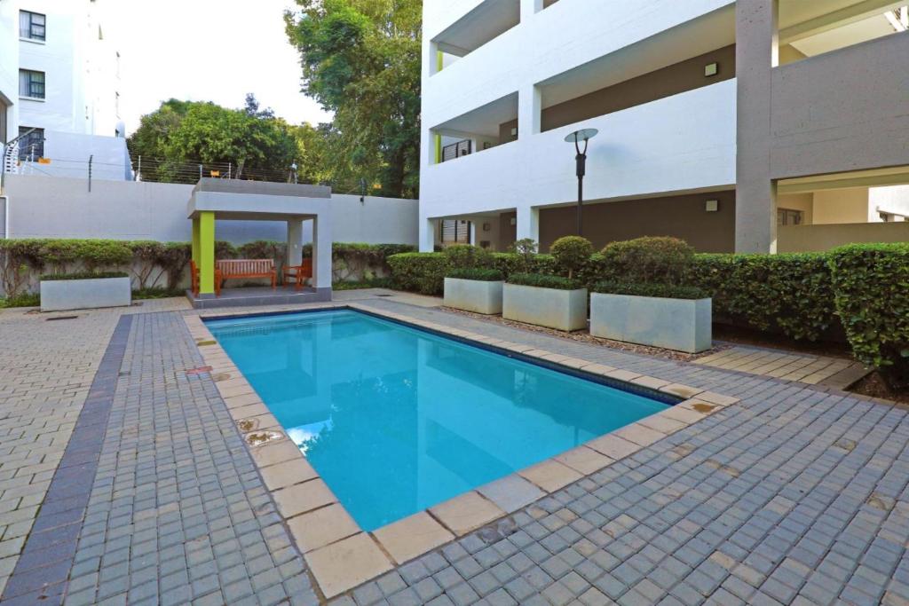 a swimming pool in front of a building at Moc Luxury Apartment in Johannesburg