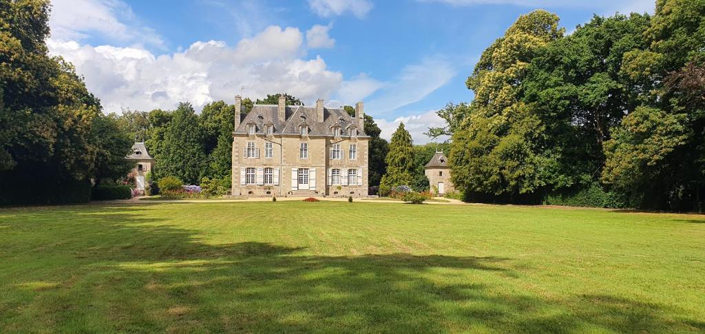 a large house with a large grassy field at chateau du Bois-Riou in Quévert