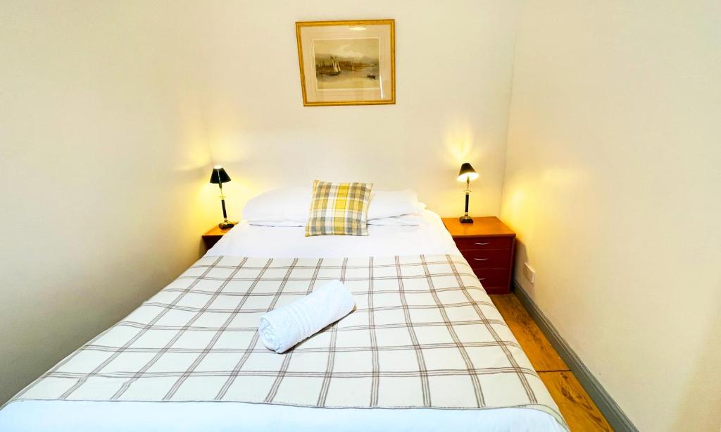een bed in een kamer met twee nachtkastjes en twee lampen bij Pentland Farm Cottage Annex in Kirknewton