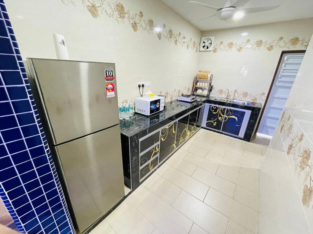 een keuken met een koelkast en een aanrecht bij Cozy Kulai Retreat 5Min AeonPalm Resort15Min Senai airport in Kulai