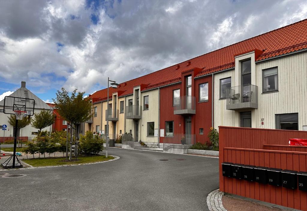 eine Reihe von Gebäuden mit roten Dächern auf einer Straße in der Unterkunft Härligt hus nära Göteborg, badsjöar och fin natur in Öjersjö
