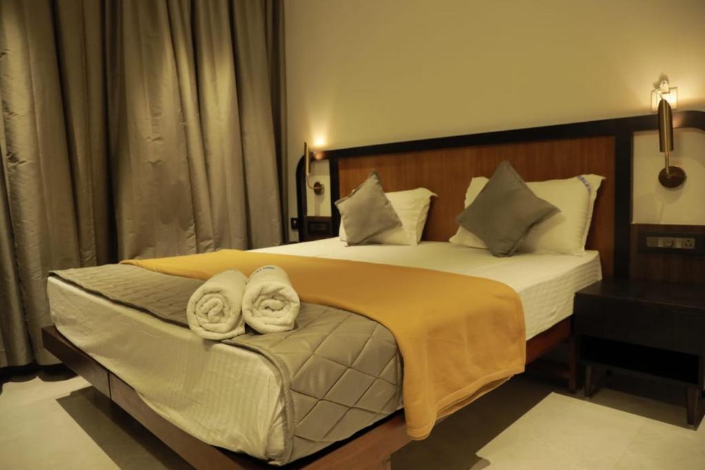 a bedroom with a large bed with towels on it at ARUNACHALA INN in Kanyakumari