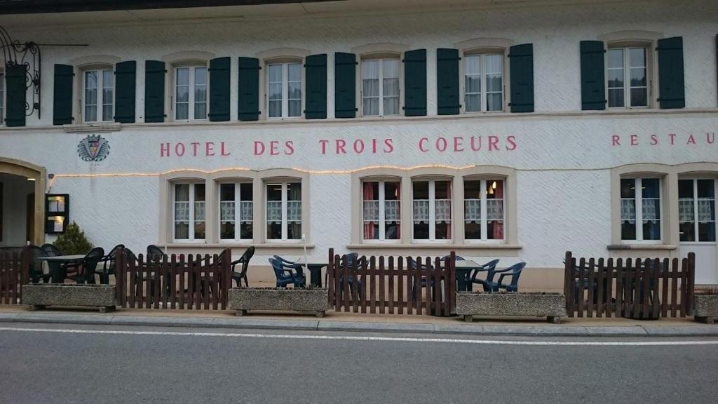 a hotel des forests colours written on the side of a building at Hôtel-Restaurant des 3 Coeurs in Vaulion