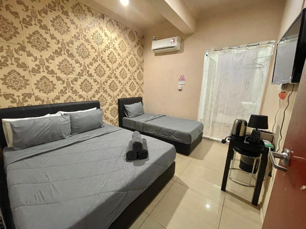 a bedroom with a bed and a couch and a television at MJ inn in Ranau