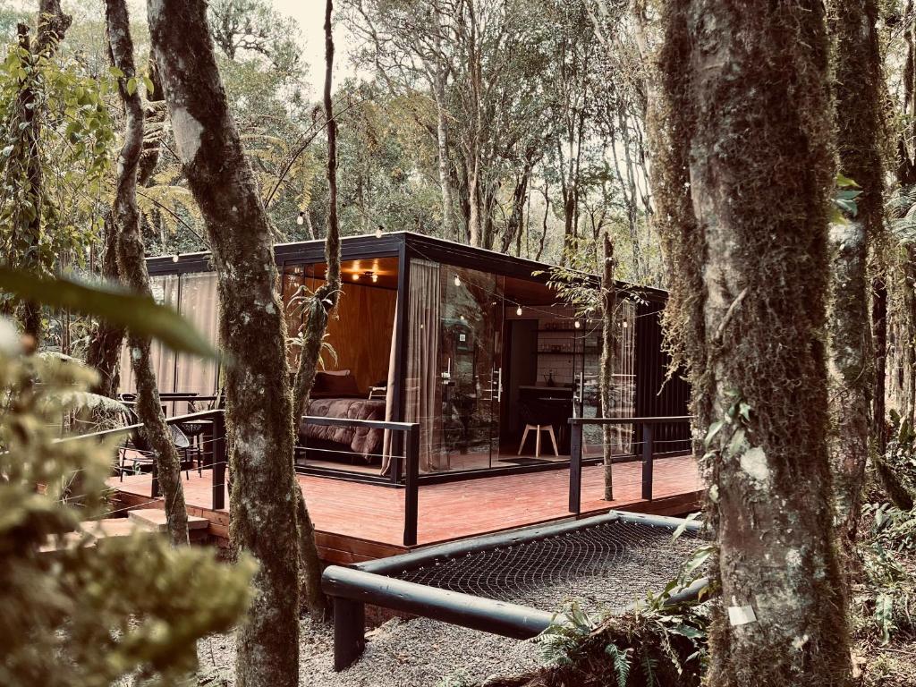 uma moderna cabana na floresta com árvores em Alpes Canela em Canela