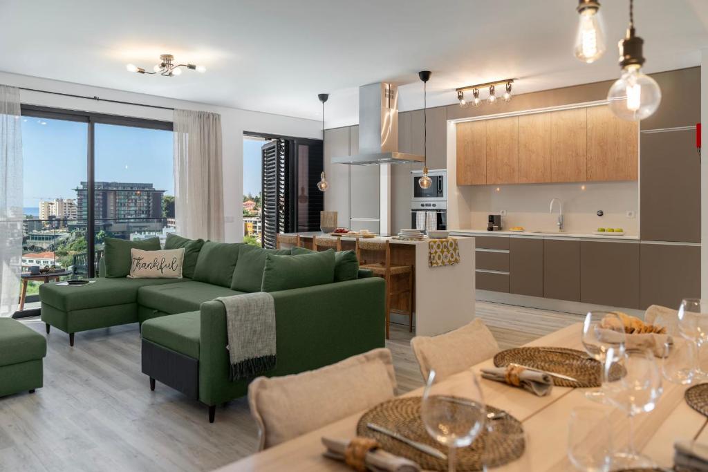a living room with a green couch and a kitchen at Uptown 13 apartment by An Island Apart in Funchal