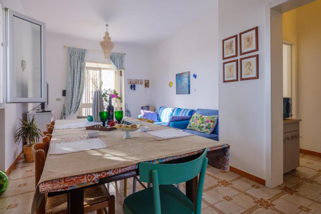 - un salon avec une table et un canapé bleu dans l'établissement Villetta la pineta, à Lequile
