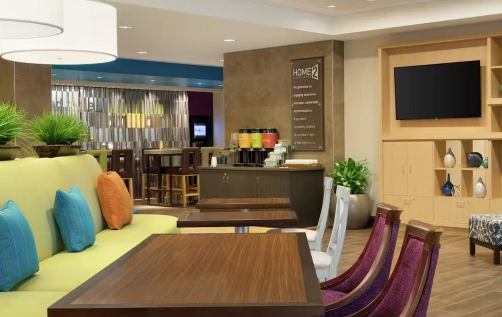 un restaurante con mesas, sillas y TV en Home2 Suites By Hilton Racine, en Sturtevant