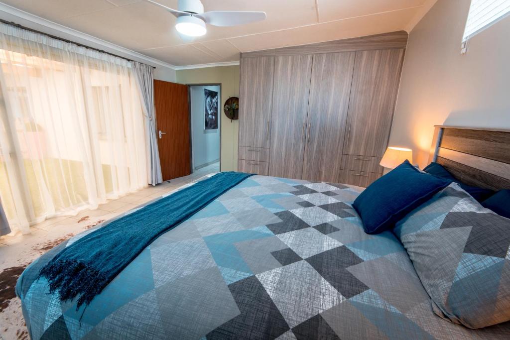 a bedroom with a large bed with blue pillows at Meerkat Manor Self-Catering & Accommodation Windhoek in Windhoek