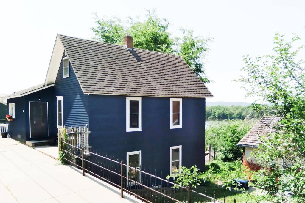 ein blaues Haus mit schwarzem Dach in der Unterkunft Bluffside cottage with gorgeous river views in Fountain City