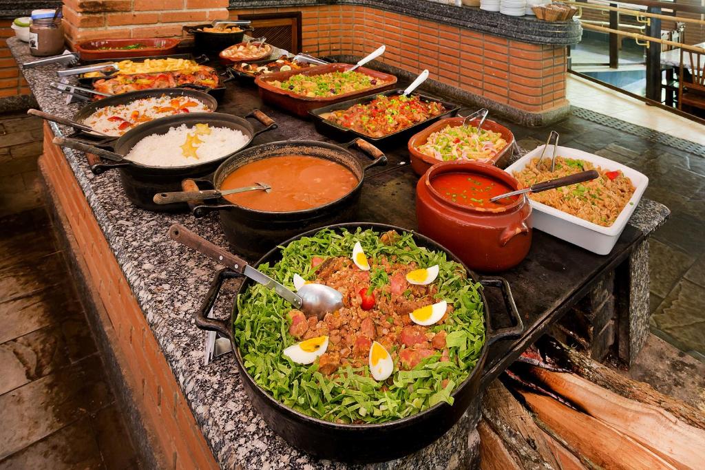 un buffet pieno di diversi tipi di cibo di Hotel Fazenda Campo dos Sonhos a Socorro