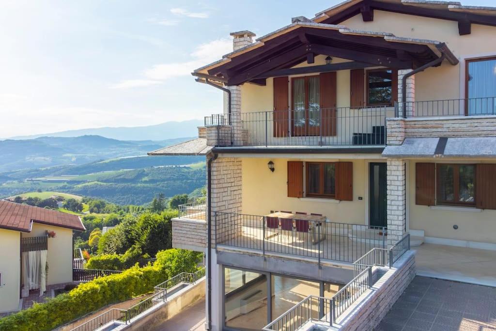 a house with a balcony and mountains in the background at La Terrazza in Lessinia, Verona in Cerro Veronese