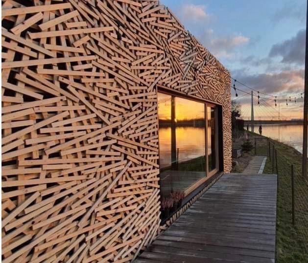 a wooden building with a wooden wall at Gniazdo 35 in Okuninka