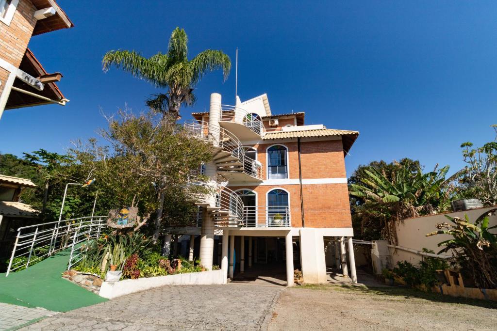 een huis met een palmboom ervoor bij Pousada Maré de Lua in Florianópolis