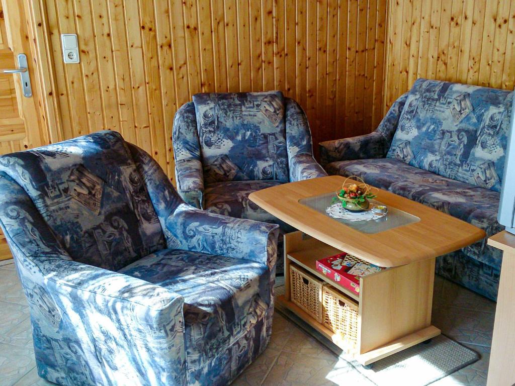 2 sillas y una mesa en una habitación en Bungalow am Waldrand, en Barth