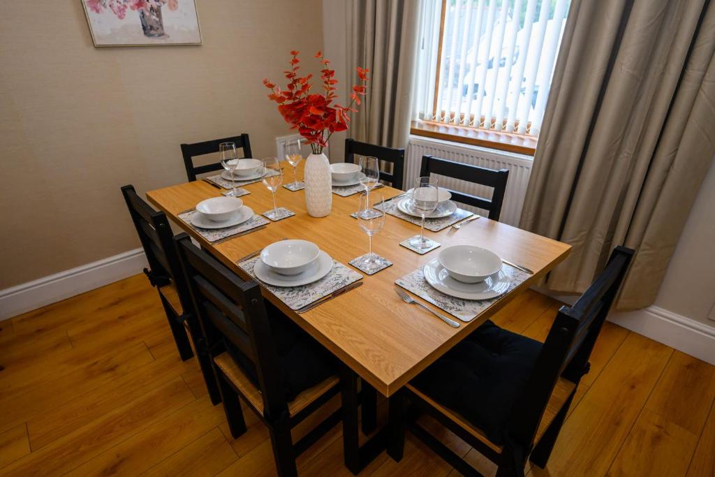 - une table à manger avec des chaises, une table en bois et des chaises dans l'établissement Heritage Cottage by StayStaycations, à Pontypridd