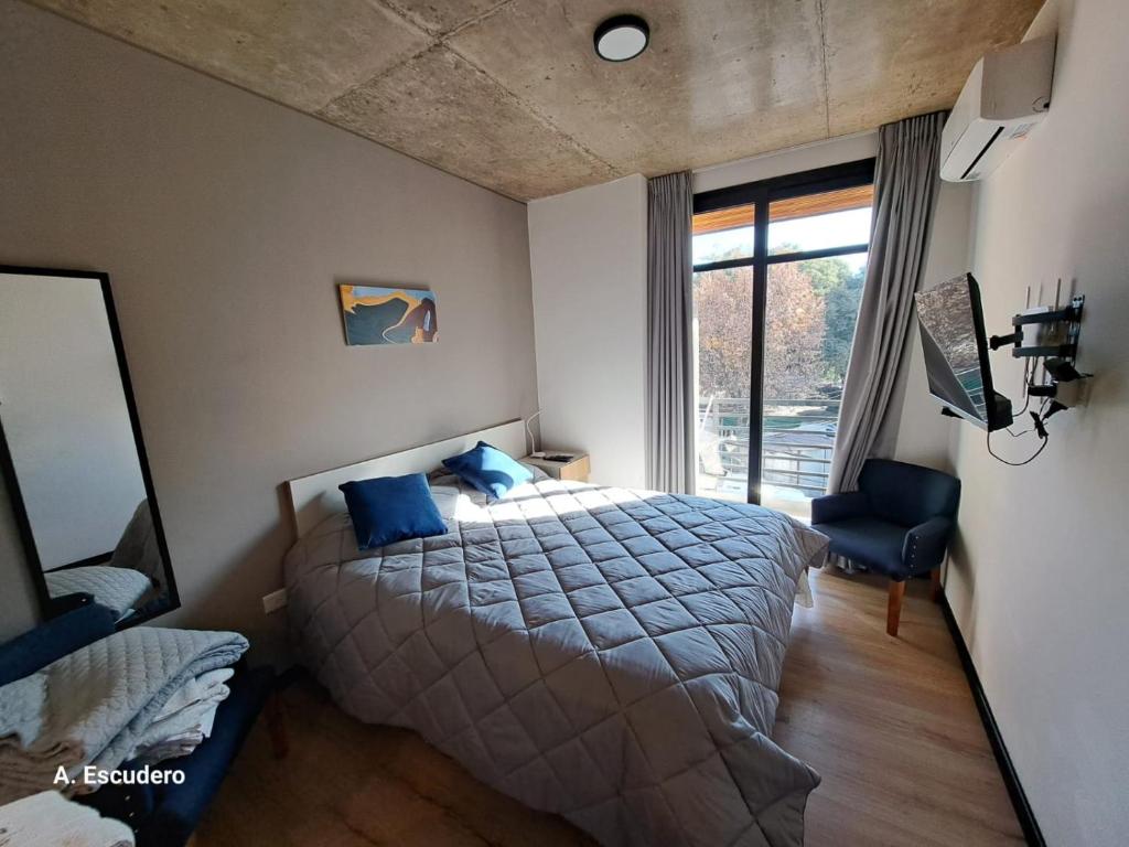 ein Schlafzimmer mit einem Bett und einem großen Fenster in der Unterkunft Departamento - Salta Capital ae - Edificio Usina in Salta