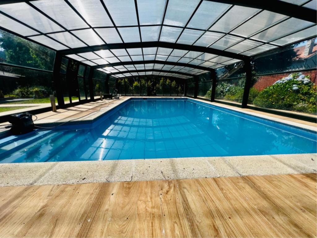 une piscine intérieure avec un toit en verre dans l'établissement Galicia Getaway - Villa Comorera, à Vilagarcía de Arousa