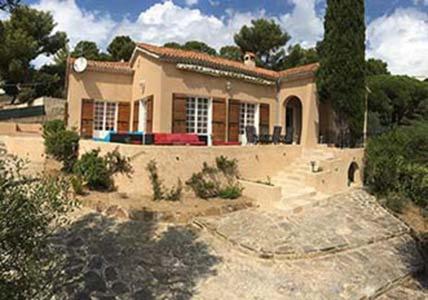 une petite maison avec une allée en face de celle-ci dans l'établissement Villa la Bergerie, à Bormes-les-Mimosas
