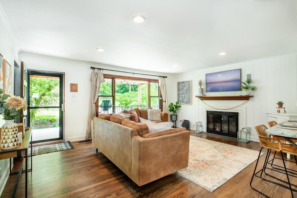 Una sala de estar con un sofá y una chimenea. en Cozy Creekside Rancher-Heart of Downtown Knoxville, en Knoxville