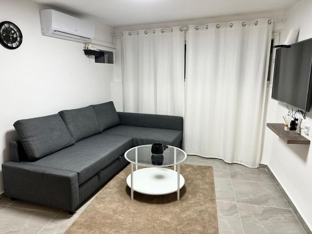 ein Wohnzimmer mit einem Sofa und einem Tisch in der Unterkunft דירת אירוח ימית in Bet Scheʼan