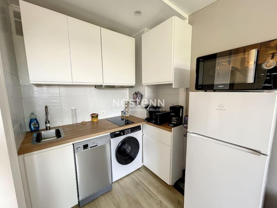 une cuisine avec des armoires blanches et un réfrigérateur blanc dans l'établissement 2980-Appartement 1 ch à 100m de la mer, à Argelès-sur-Mer